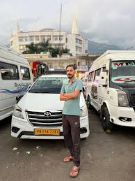 a person is standing in front of car of thakur tour and travels, which are the best tour and travel in pathankot